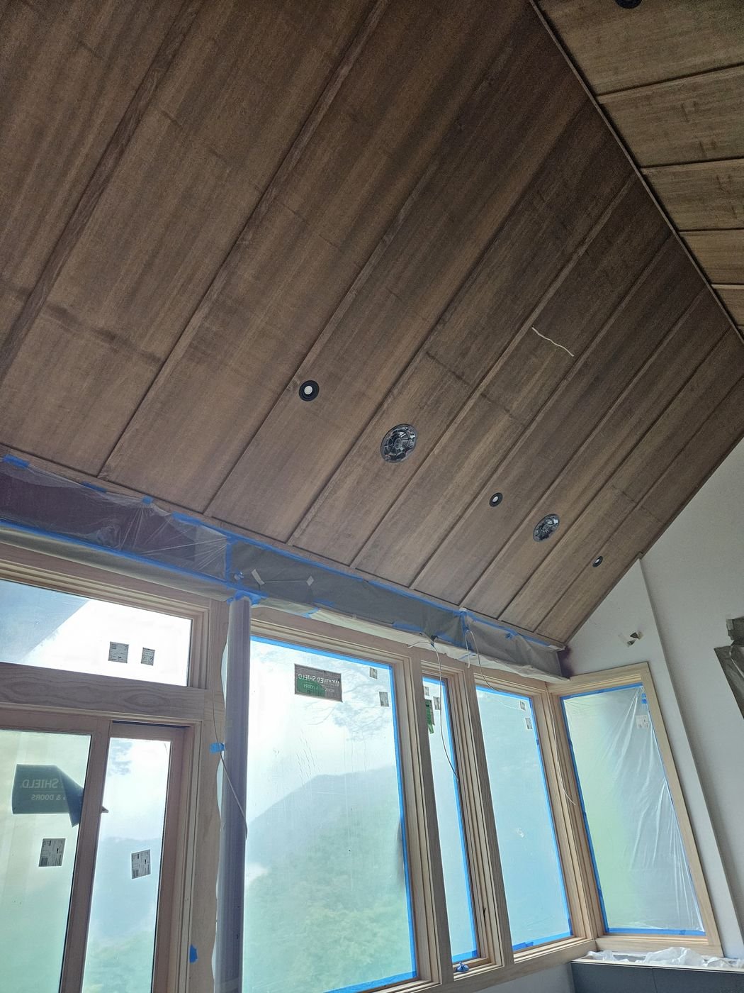 Wood plank vaulted ceiling over large windows, in progress