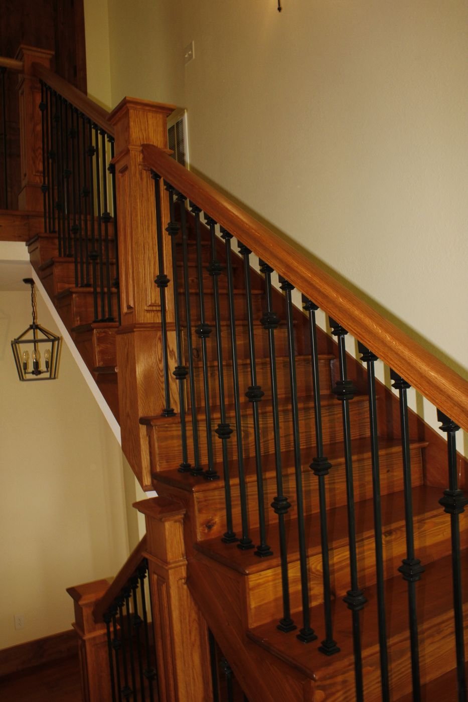 Double-flight oak staircase with wrought iron balusters