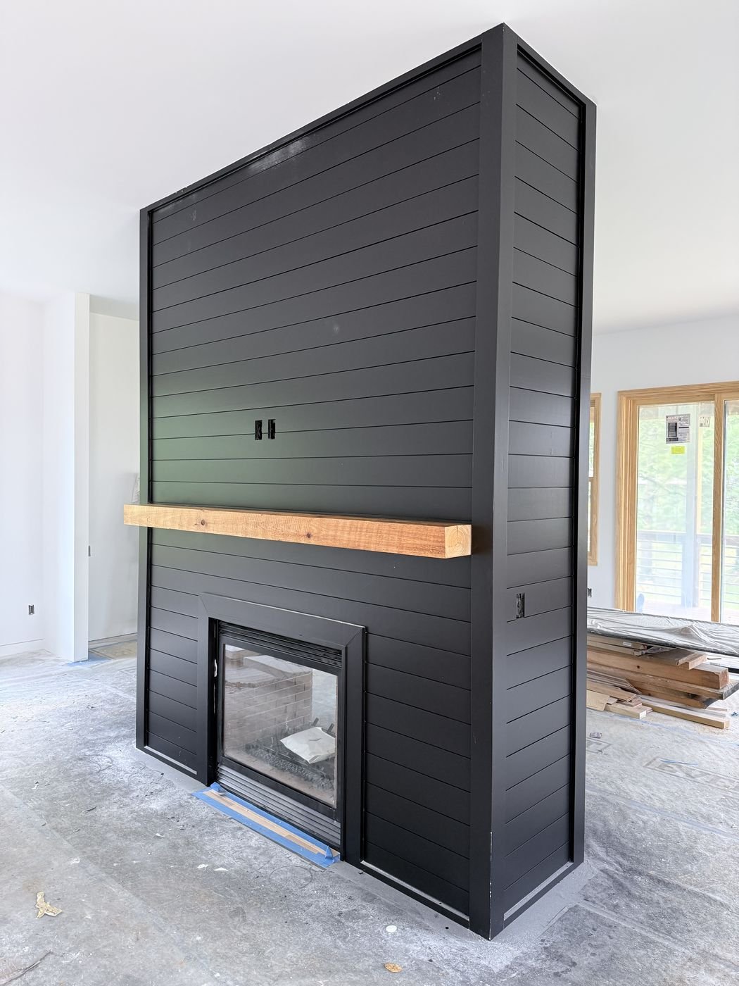 Modern black shiplap fireplace surround under construction