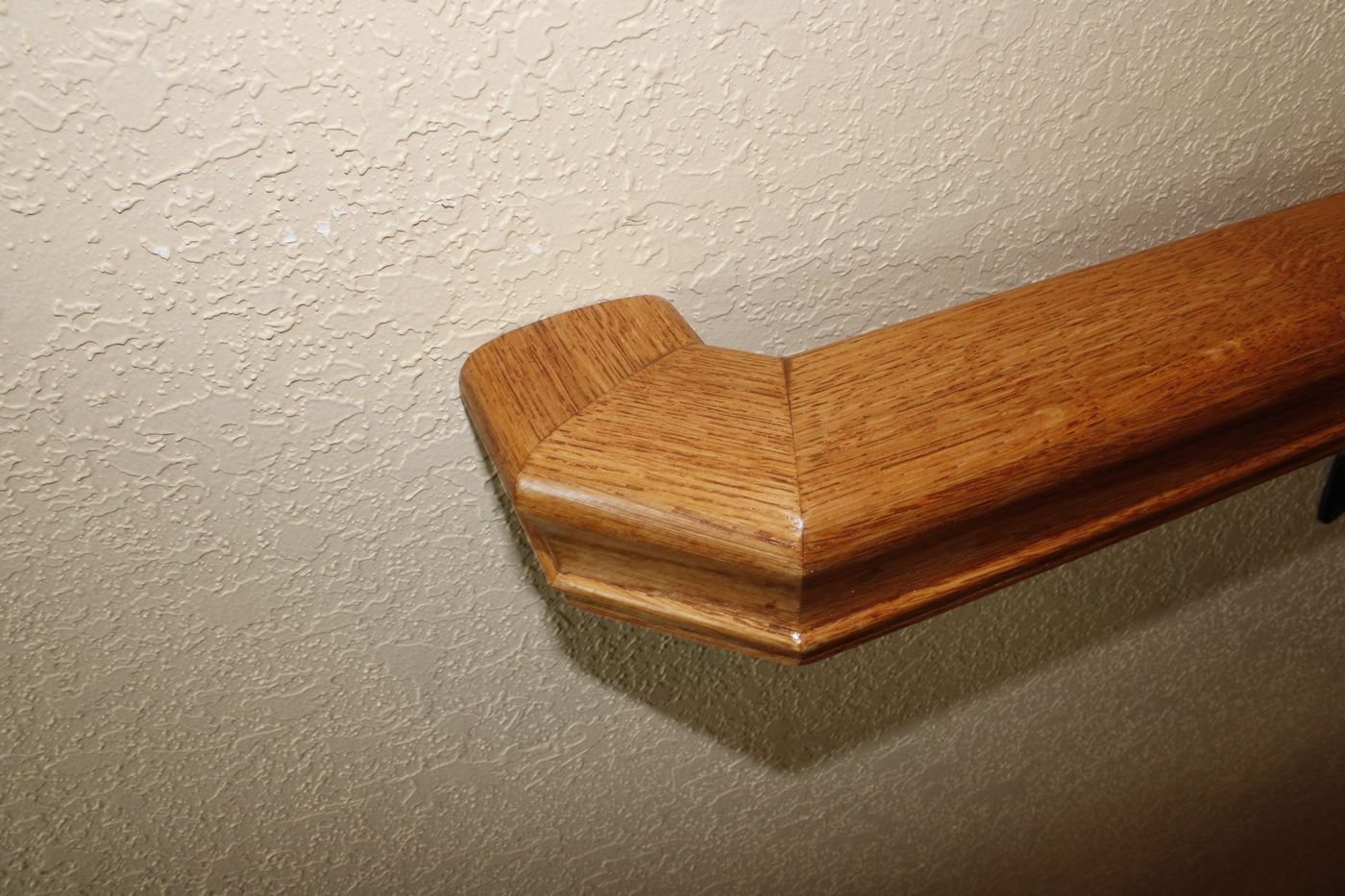Wood stair handrail end detail, oak finish