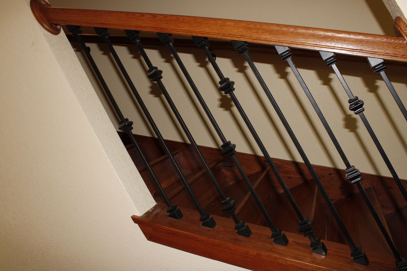 Wood staircase railing with wrought iron balusters