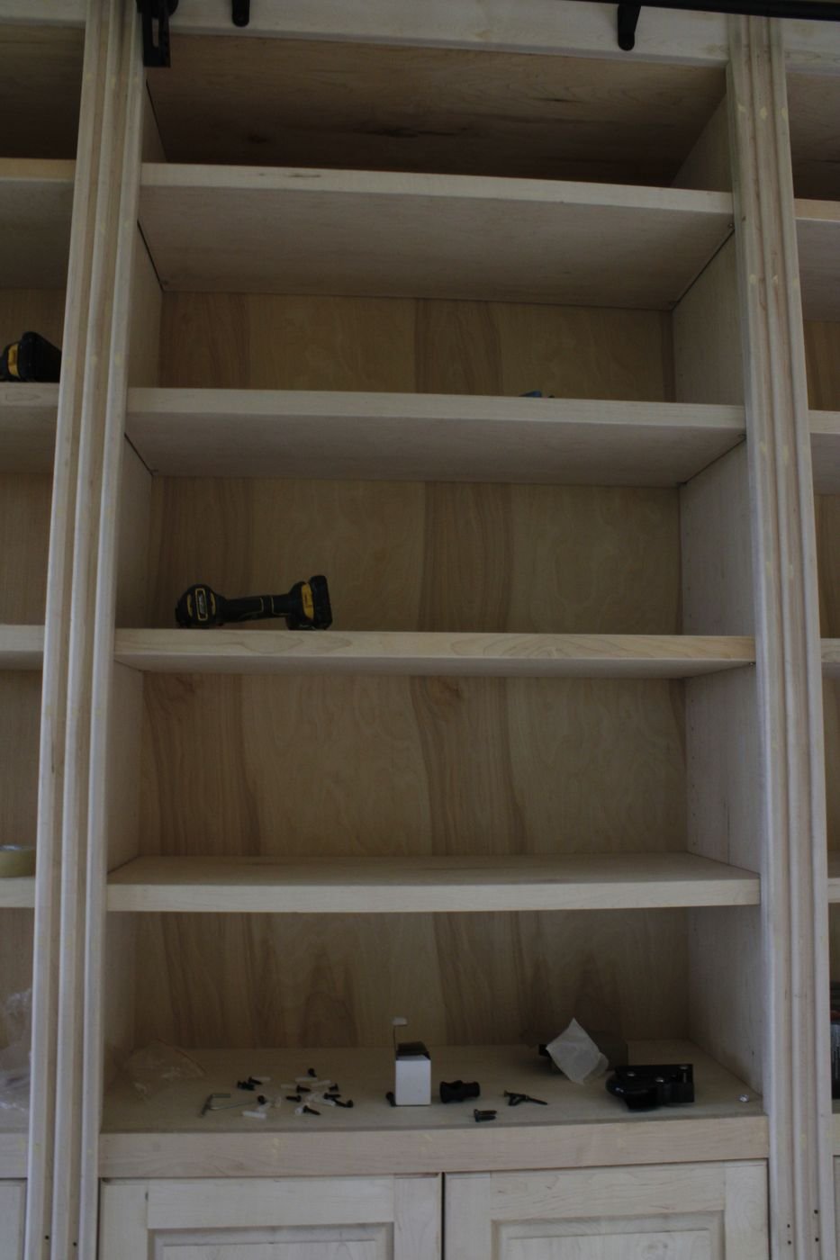 Built-in library shelving detail with sliding ladder rail