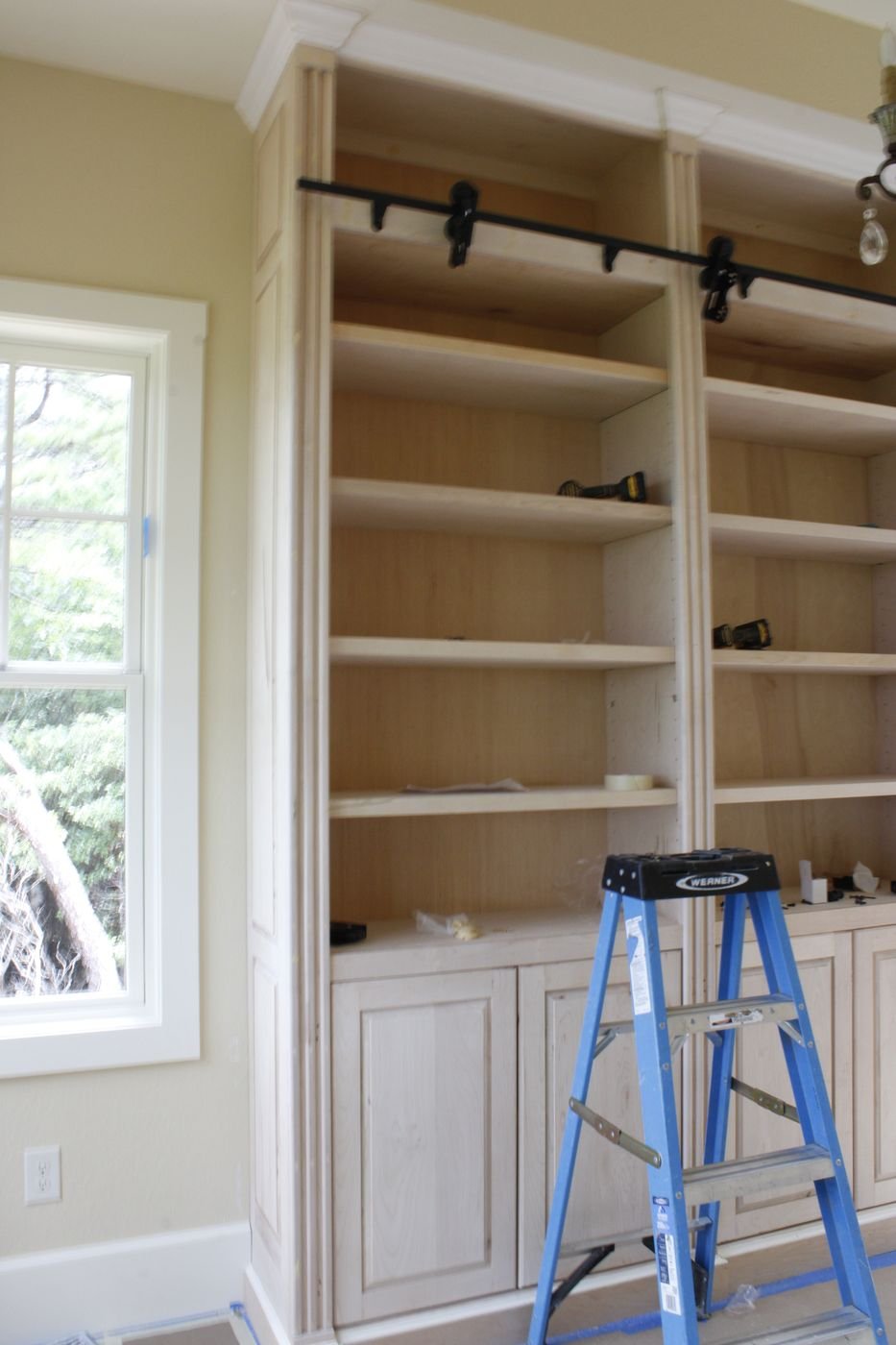 Built-in library shelving with sliding ladder rail