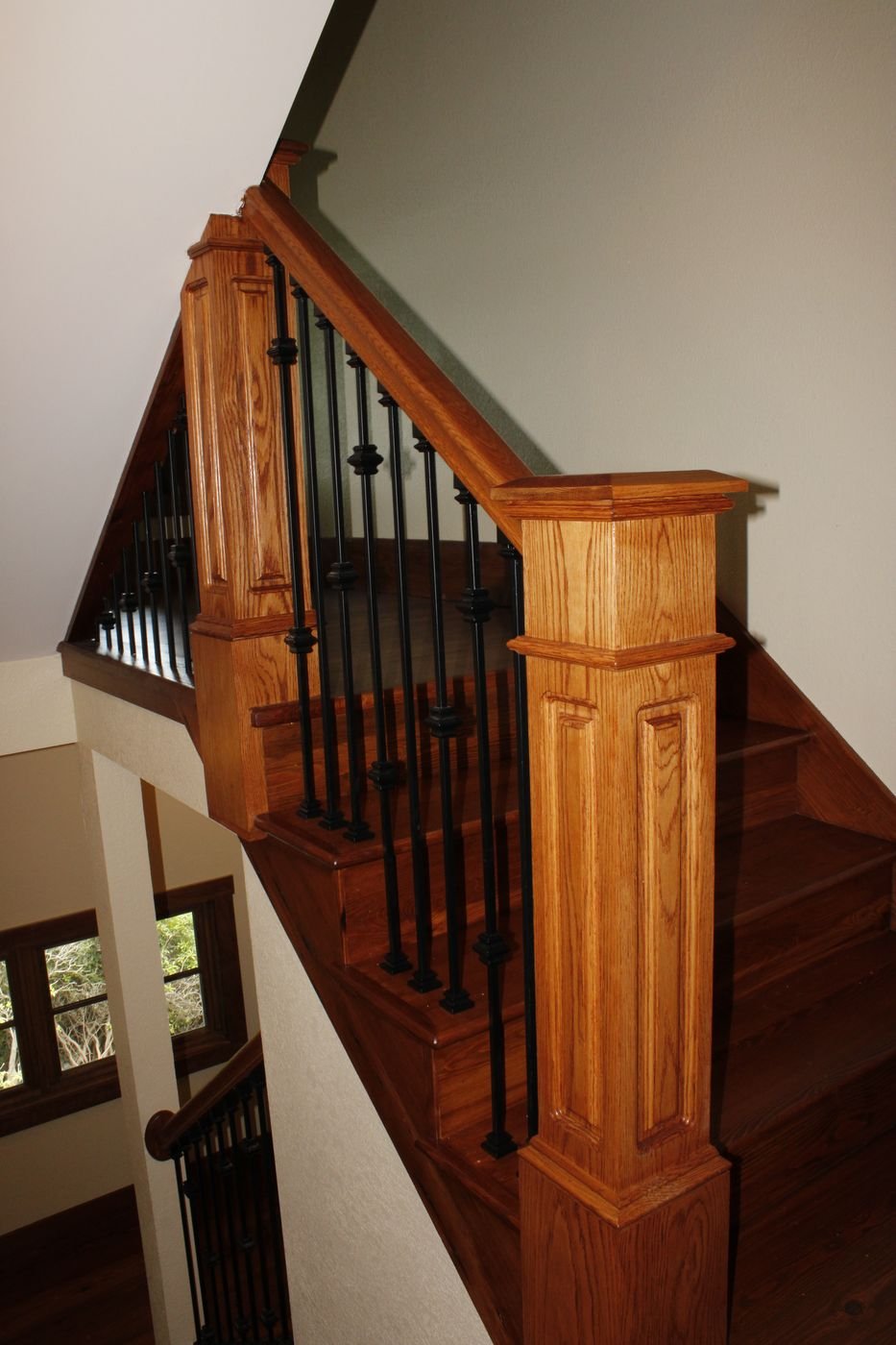 Oak stair newel post and balusters on a finished staircase