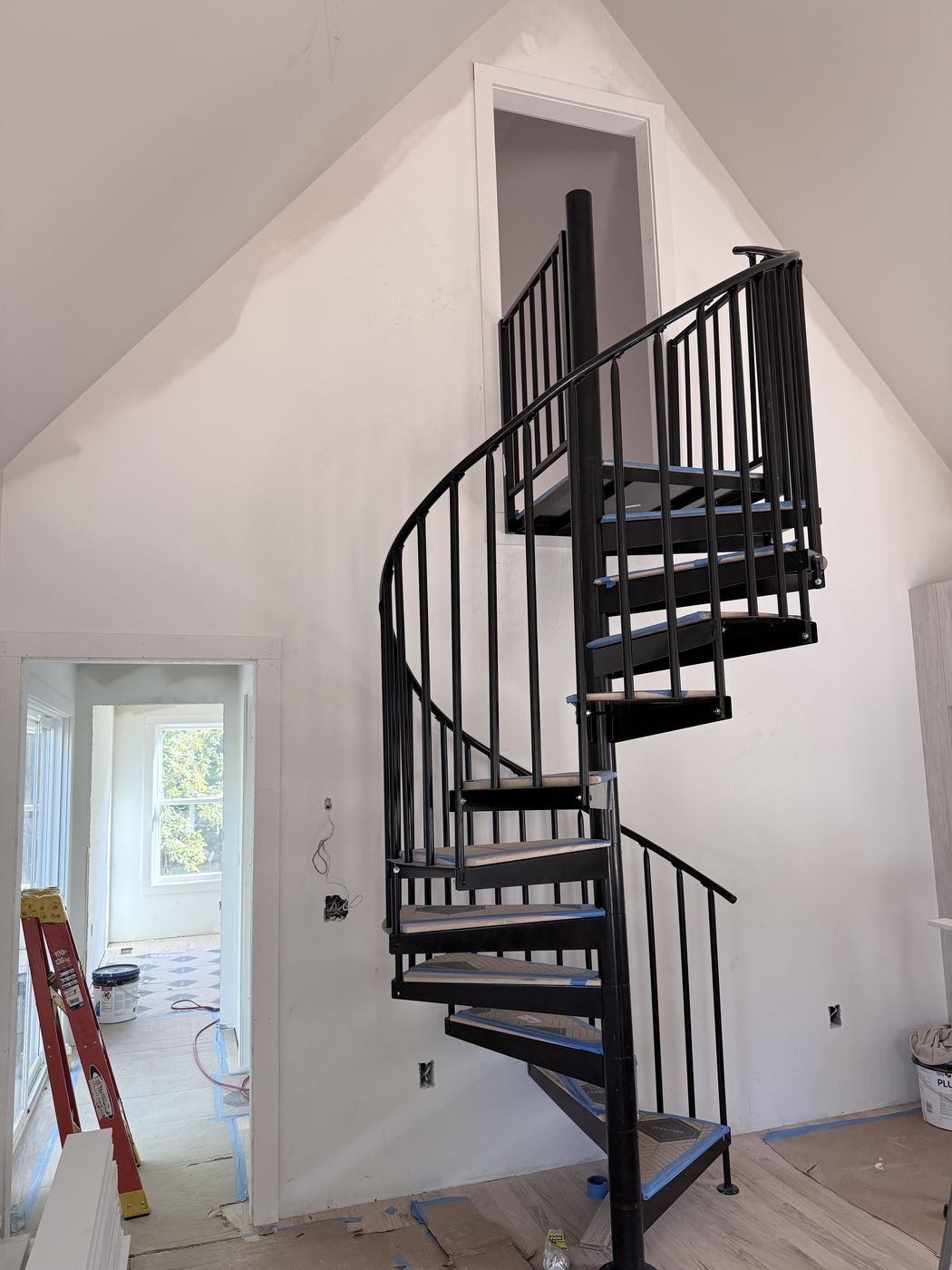 Modern black spiral staircase in a vaulted stairwell