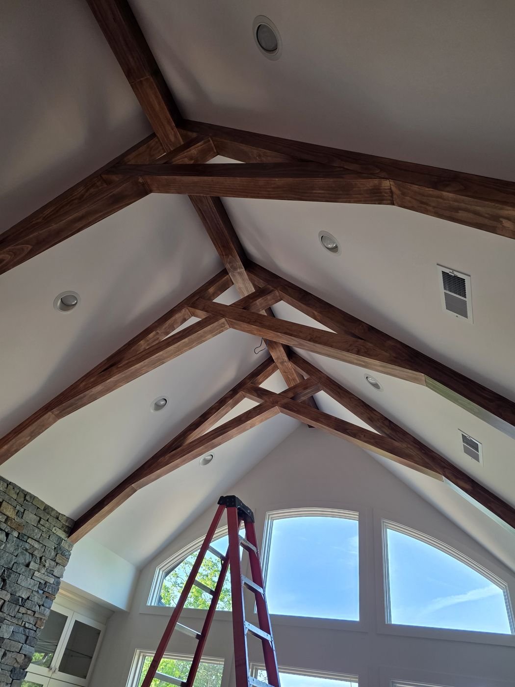 Custom stained wood ceiling trusses in a vaulted living room